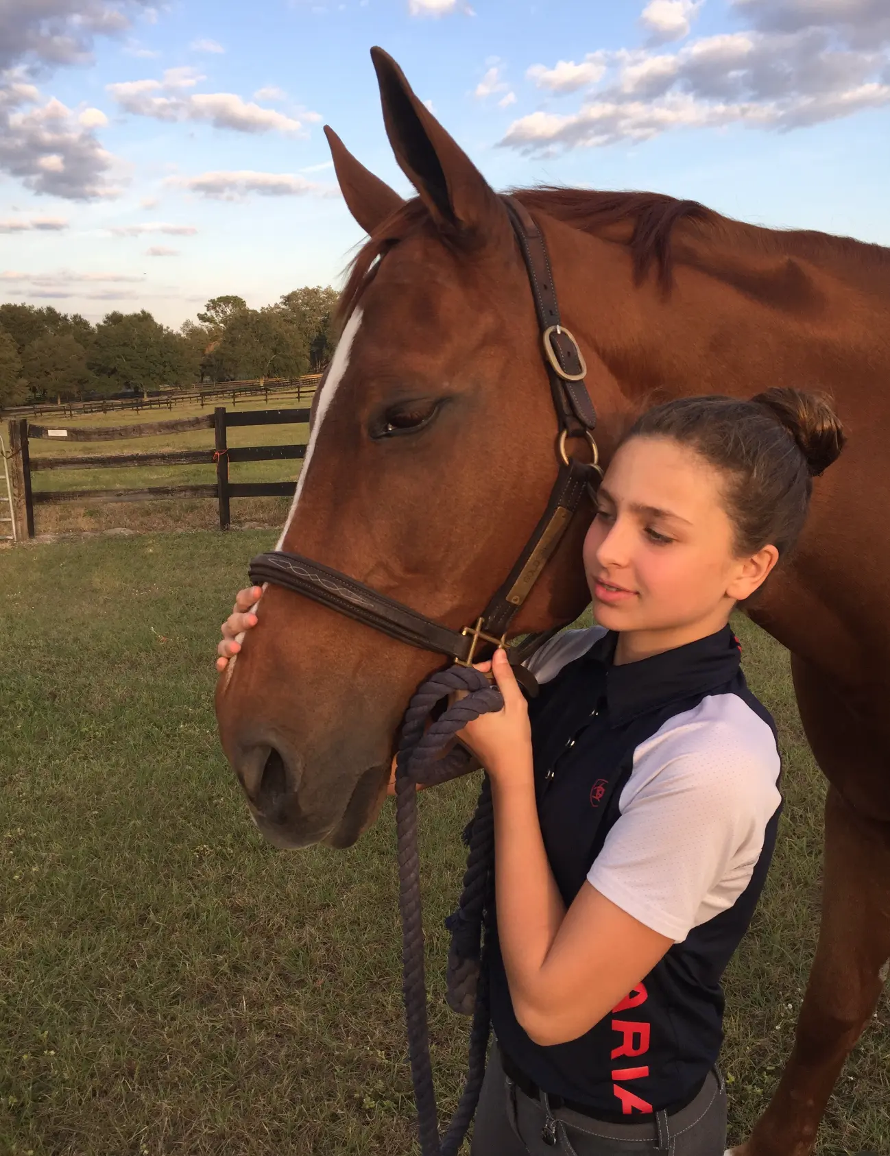 A young Sophia haltering her horse at golden hour