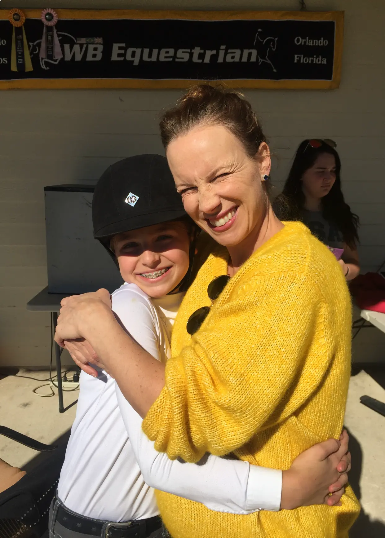 A young Sophia hugging her mother at WB Equestrian after a class